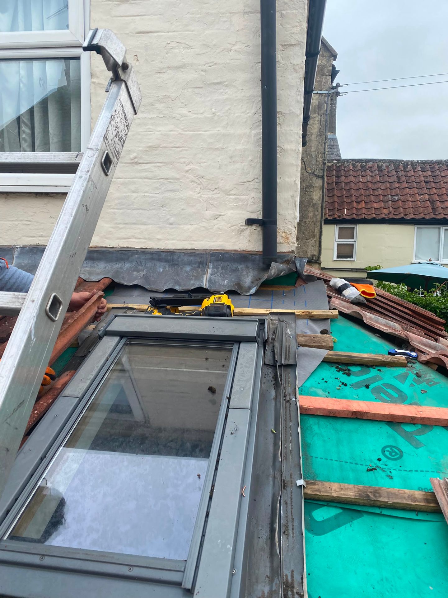Velux roof window installation in progress with new lead flashing and membrane