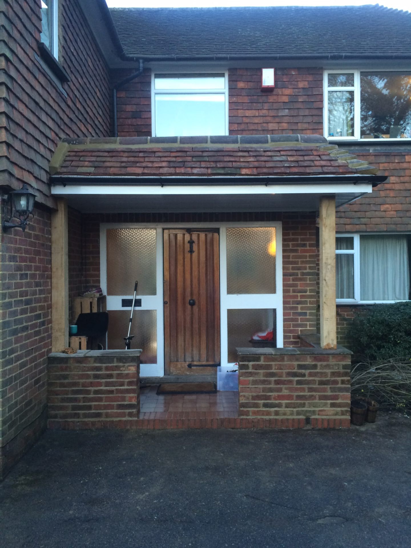 Newly built front porch with tiled canopy roof and oak posts